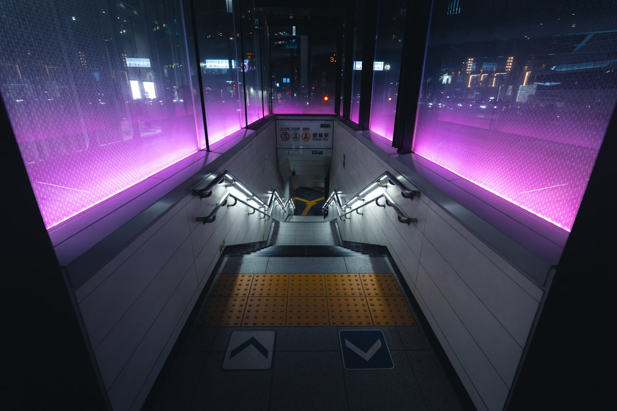 A train station with purple lights on the walls